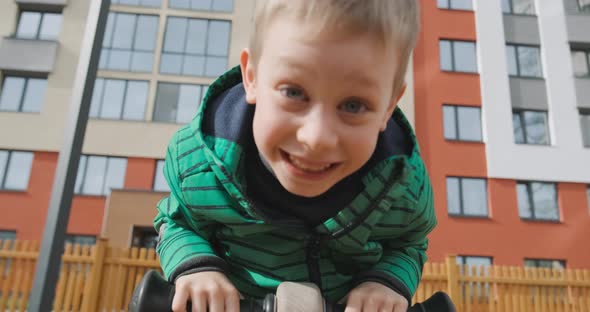 Small Child Riding Toy Horse Swing Playing on Playground