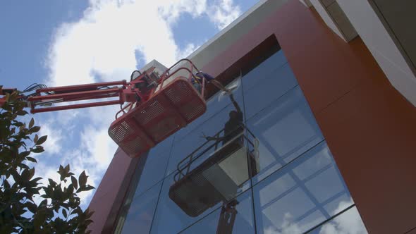 Window cleaner on the facade of a glass building alt