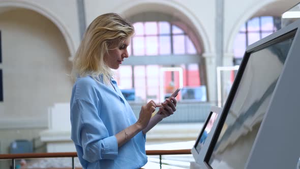 woman with a phone at the interactive display