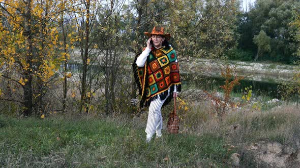 Attractive Senior Mature Woman in Bright Clothes Walks Through Autumn Park alt