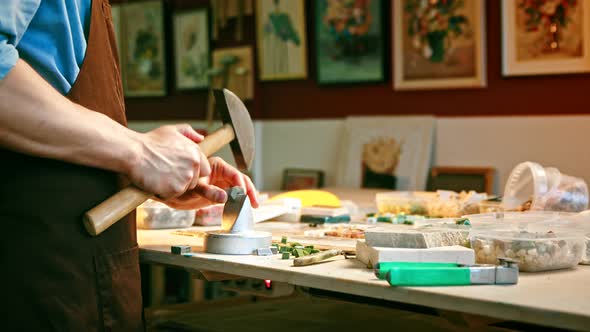 Young man with a hammer at work alt