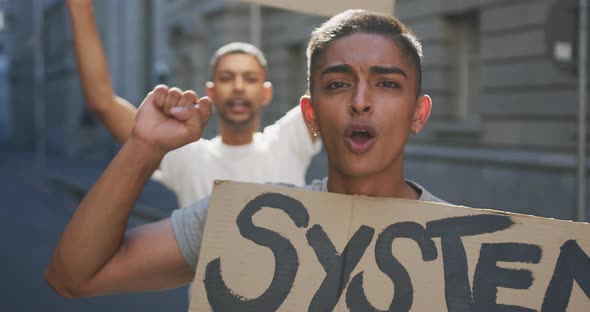 Two mixed race men on a protest march holding placards raising hands and shouting alt