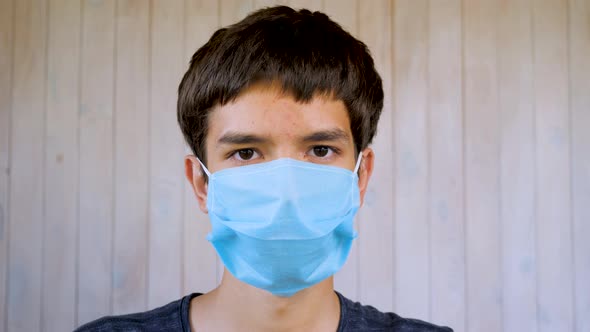 Boy in Medical Facemask Looking at Camera. Coronavirus, Covid-19 Outbreak. Brown Eyes of 6 Years Old alt