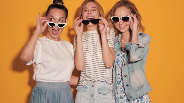 Three young beautiful smiling hipster girls in summer clothes alt