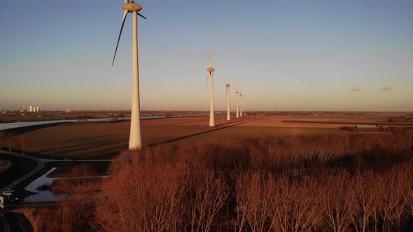 Dolly shot of wind turbines in a golden field. Sustainability concept alt
