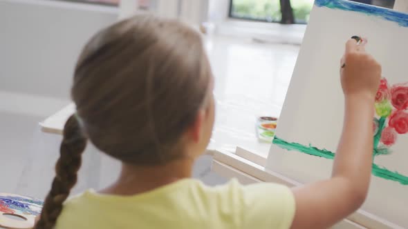 Video of back of caucasian girl painting during art lessons at school alt