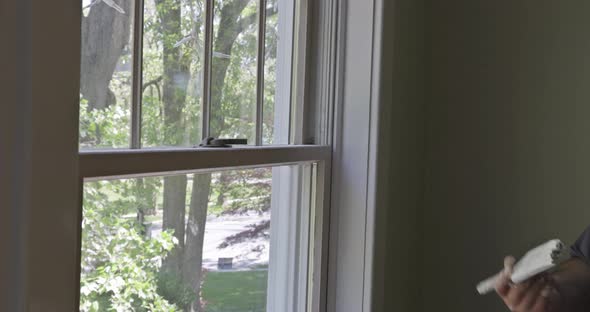 Home Renovation in the Handyman Paints with a Paint Brush a Window Molding Frame alt