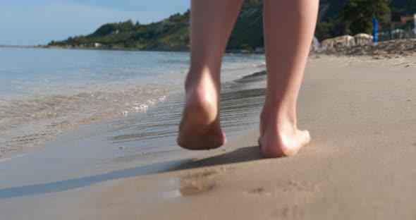 Child Walking Barefoot on Sand alt