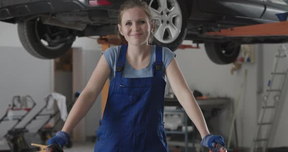 Smiling female mechanic working in the auto repair shop