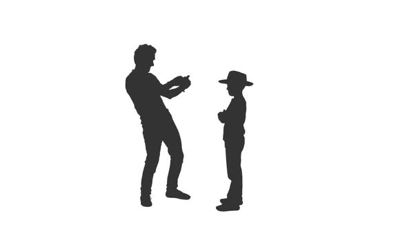 Silhouette of Man Takes a Photo of His Little Son With Mobile Phone