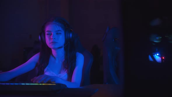 Two Beautiful Gamer Girls Playing an Online Game in the Neon Gaming Club alt