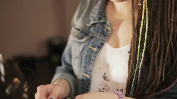 Closeup Portrait of a Female Stylish Hairdresser Doing Dreads for a Young Smiling Woman in the Hair alt