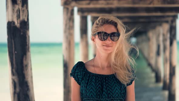 Dreamy Woman Smiling And Relaxing On Beach. Stress Free Girl In Summertime Season Sundress Leisure. alt