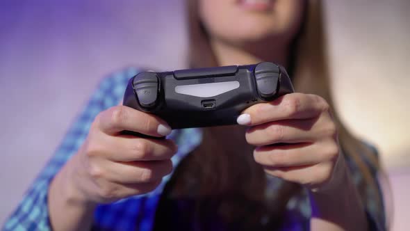A Young Woman is Playing a Game Console