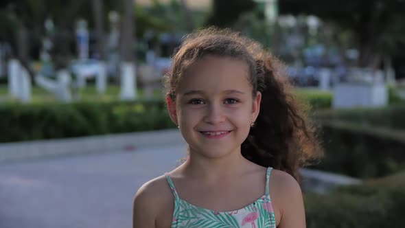 Portrait of a Funny Little Girl Looking at Camera Smiles, Beautiful Smile, Sunny Summer Day, Cute alt