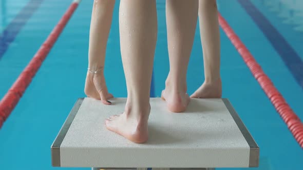 Professional Concentrated Female Swimmer on Starting Block. Jump Into Water alt