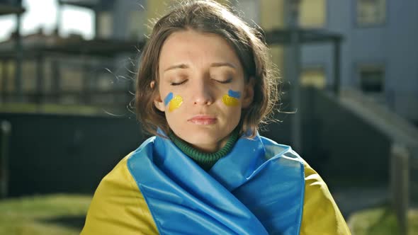 Portrait of a Woman with a Ukrainian Flag on His Shoulders