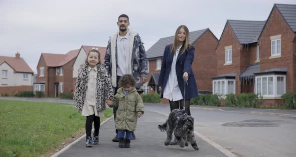 Happy multiracial family having a walk together on the pavement