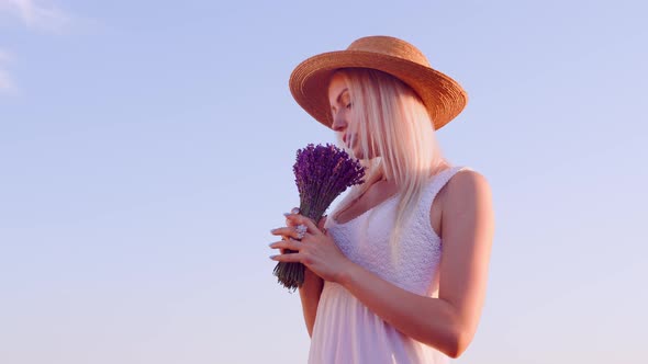 Blonde Woman Holding Bouquet of Lavender in Lavender Field