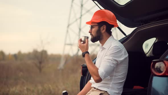 Tired Worker And End Working Day. Investor On Build Object. Engineer In Helmet On Power Lines. alt