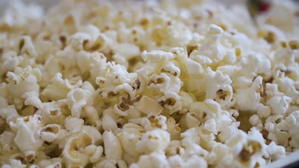 Kid's hands grabbing popcorn from a large bowl alt