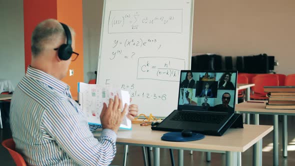 Male Tutor Is Communicating with His Students Via the Internet alt