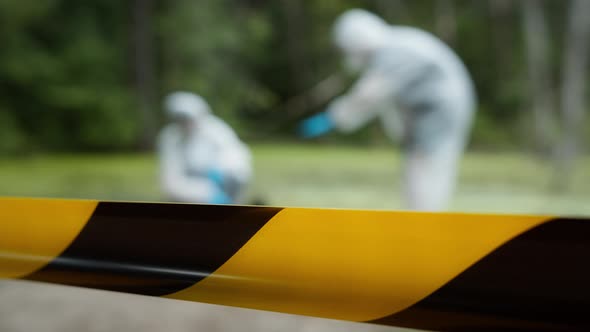 Criminalists Working with Proofs at Crime Scene Territory Closed with Signal Tape alt