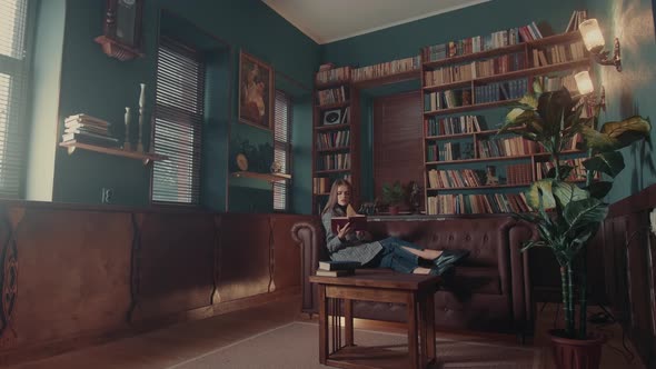 Young Attractive Caucasian Woman Flips Through the Pages and Gets Acquainted with the Contents of alt