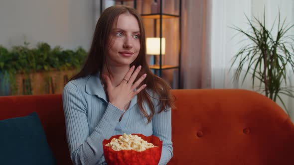 Woman Sitting on Couch Eating Popcorn and Watching Interesting TV Serial Sport Game Online at Home alt