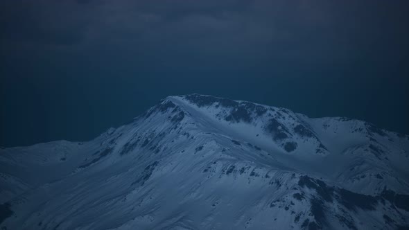 Dramatic Dark Rocky Mountain with Patches of Snow in Storm alt