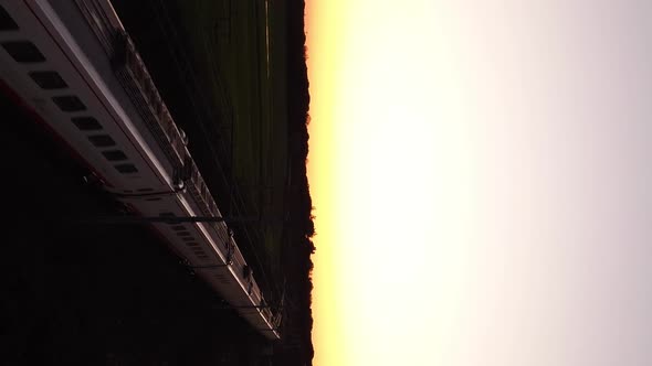 Vertical video of train passing in the sunset alt