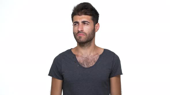 Caucasian Young Man Wearing Grey Tshirt Looking at Camera Expressing Misunderstanding Throwing Up alt