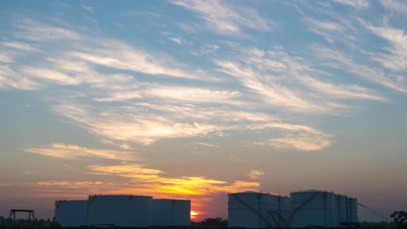 4K Time lapse of sunset twilight sky over big industrial oil tanks