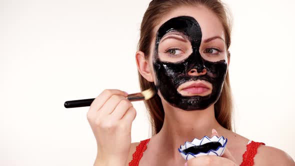 Girl Applying Black Carbo Mask to Face