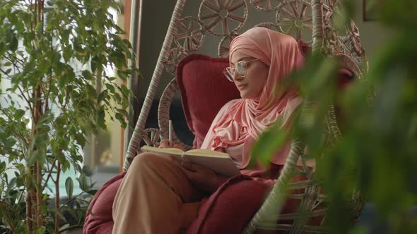 Mixed-race Woman Writing in Notepad in Restaurant alt