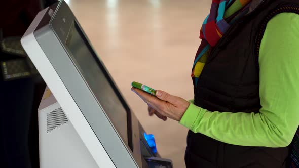 Closeup of woman holding smartphone and doing a self check in at the airport. alt