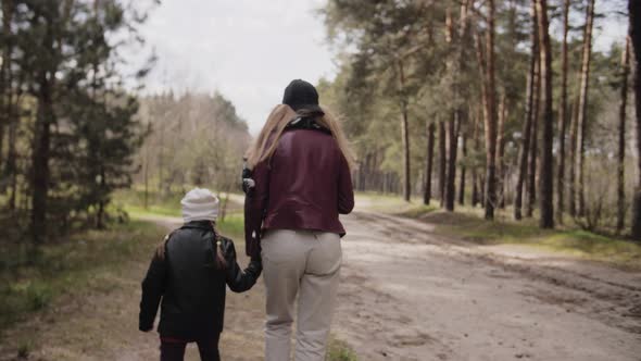 Mother and Daughter Walk Together in the Forest. 