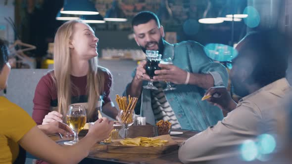 Group of young multiracial friends drinking beer in bar