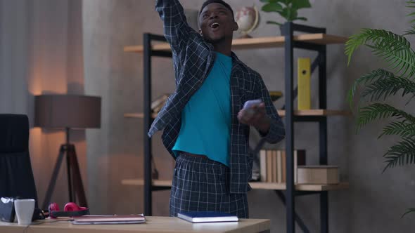Excited Happy African American Man Scattering Documents Checking Email on Smartphone alt