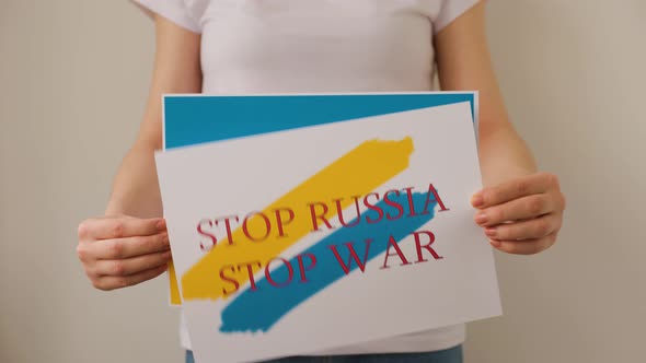 Hands is Holding a Poster with the Image of the Ukrainian Flag Which Says Free Ukraine Stop War alt