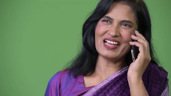 Close Up Shot of Mature Happy Beautiful Indian Woman Talking on the Phone While Thinking alt