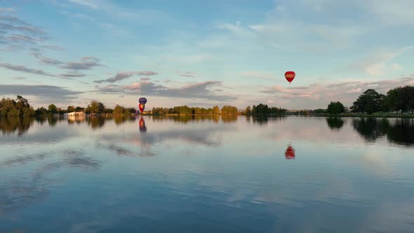 Hot air balloons taking off and heading over Hamilton City in New Zealand for Balloon festival. alt