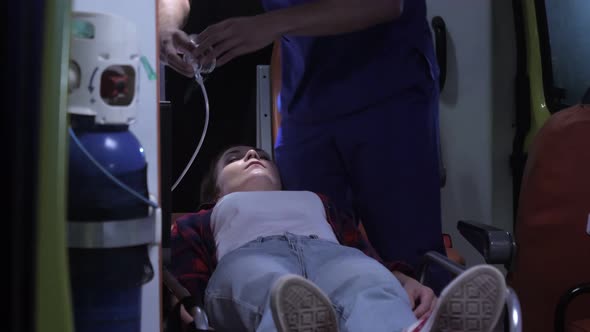 Corpsman Put an Oxygen Mask on Woman's Face. alt