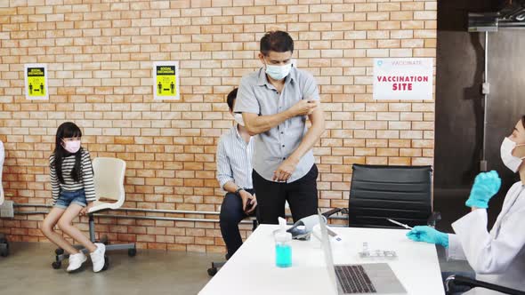 Coronavirus Vaccination.Doctor syringe injection to the young patient put on a mask