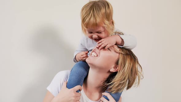 Portrait of a happy mom and her daughter playing and having fun together. alt