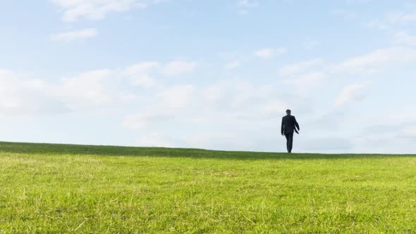 Businessman walking over a hill