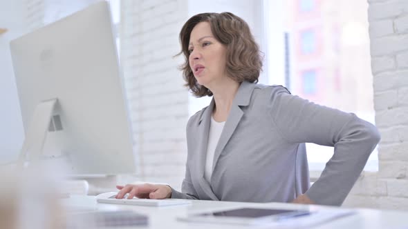 Creative Old Woman Having Back Pain in Office alt
