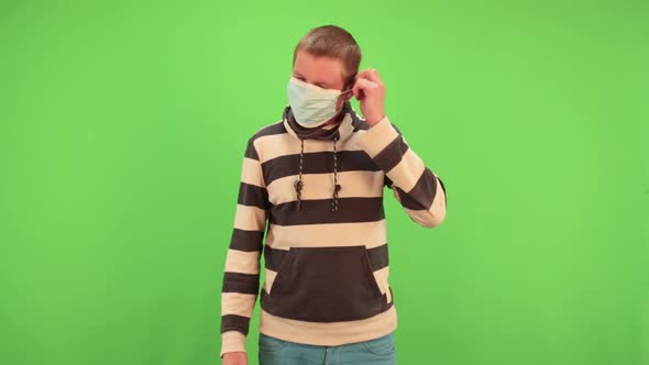 Man Puts on Medical Mask on a Chromakey. Virus Protection Gel, Disinfectant. Prevent Spread of alt
