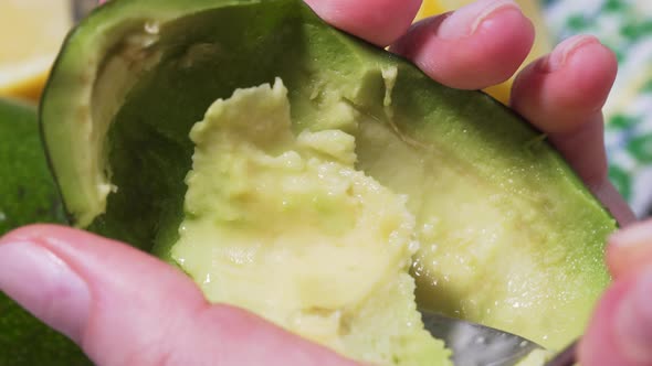 Guacamole Recipe, First Step. The Hand Pulls Out a Spoonful of Avocado Pulp, a Static Macro Shot