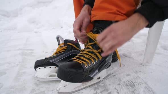 Men's Hands Tighten the Laces on Skates